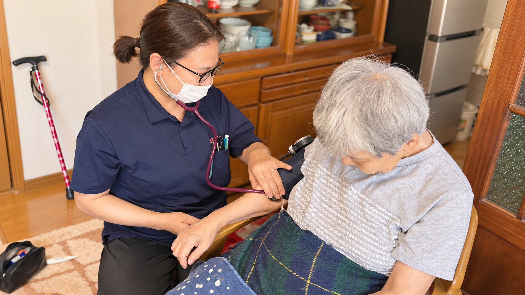 ご自宅で利用者様の血圧を確認する看護職員